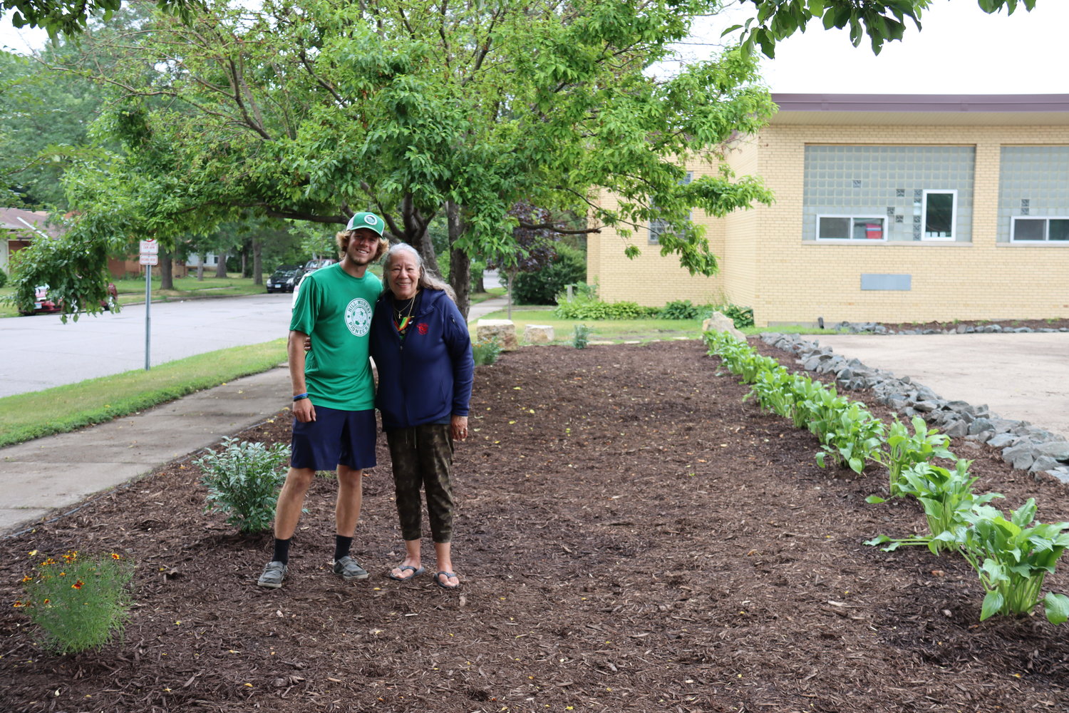Joshua ‘JP’ Yocum of Pioneer Landscaping and Lynn Wright appreciate how the new landscaping at St. Peter Claver Catholic School turned out. (Photo by Tesha M. Christensen)