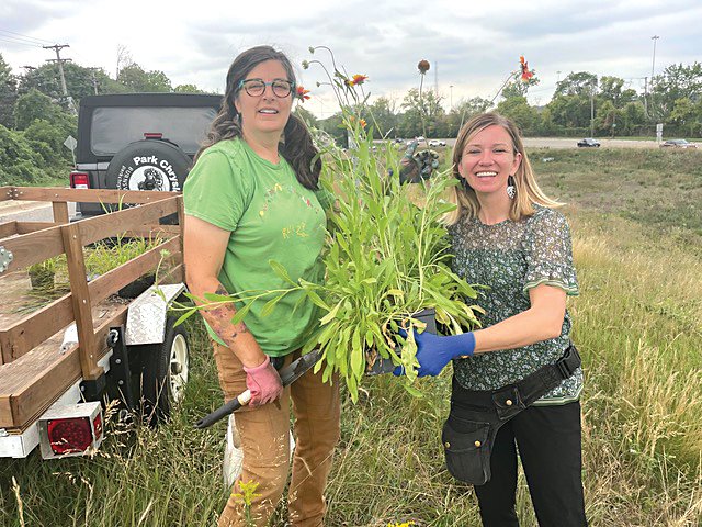Steph Hankerson (left) and Sarah O’Brien hold a blanket flower while working at Pierce Butler Meadow. (Photo submitted)