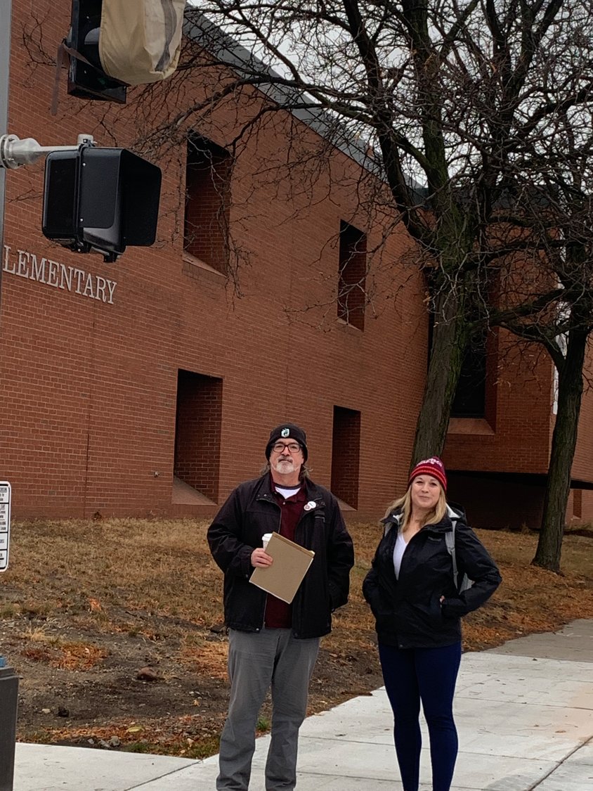 Mike Reynolds (left) and Jessica Kopp stand by the new stoplight at Snelling and Englewood. (Photo submitted)
