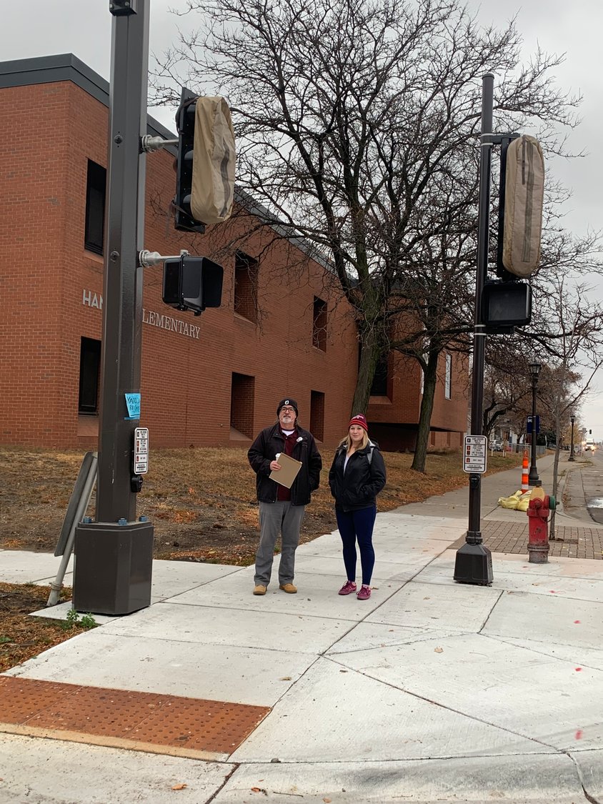 Mike Reynolds (left) and Jessica Kopp stand by the new stoplight at Snelling and Englewood. (Photo submitted)