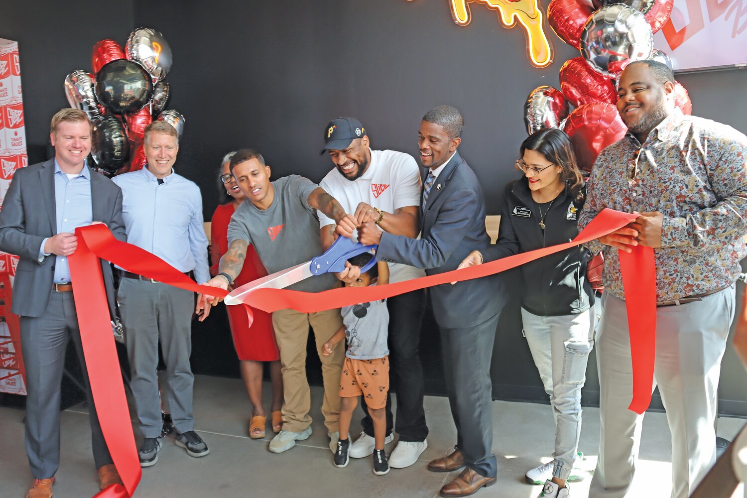 Best friends Adam Kado (second from left) and Hosie Thurmond (second from right) celebrate the grand opening of their third pizzeria on Sept. 15, 2023. Among those joining them were Neighborhood Development Center President and CEO Renay Dossman, Mayor Melvin Carter, and little Hosie Thurmond, Jr. “I was born and raised in St. Paul,” said Kado. “This is priceless to me.” >> (Photo by Tesha M. Christensen)