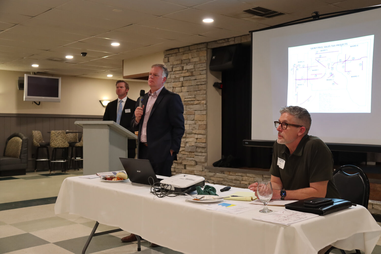 Minnesota Retailers Association President Bruce Nustad (second from left) and St. Paul Public Works Director Sean Kershaw speak at the Midway Area Chamber of Commerce luncheon on Oct. 18 about how the proposed 1 percent tax increase might affect the business community.
