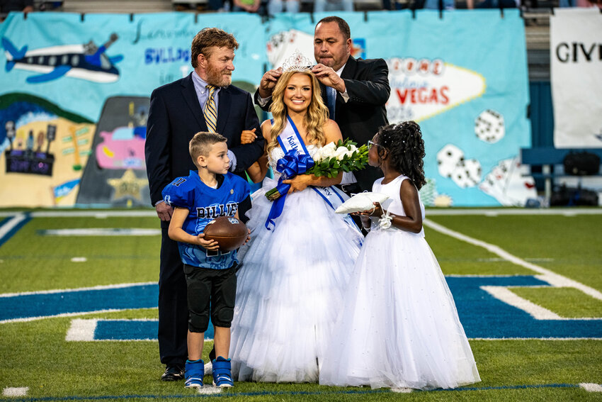 CURT PRESTON, Monitcello School Board President, crowns KATIE STANDLEY as her dad Clayton Standley escorts her as the 2024 Monticello Billies Homecoming Queen in the hOmecoming ceremony held before the Billies kicked off against Star City for their Homecoming contest at Hyatt Field on Friday night.