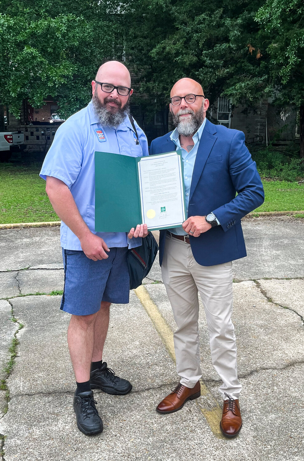 Monticello Mayor Jason Akers (right) presents Michael Burns with a proclamation recognizing the Stamp Out Hunger Food Drive which is carried out each year by postal workers across the United States on the second Saturday in May.