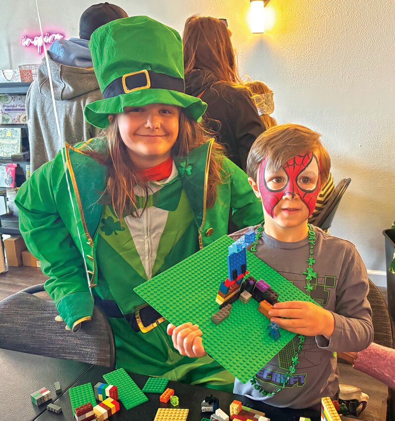 John Hoover, 5, from Morrisville, proudly holds up his Lego building while sitting next to Leprechaun Ande Amadon.