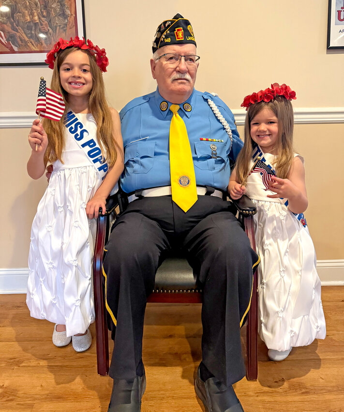 Walt Davidson, Post Commander, sits between Miss Poppy 2025 (left) and Little Miss Poppy 2025.