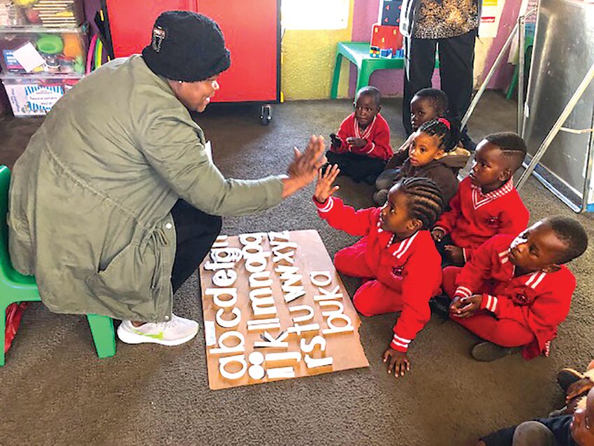 These children are learning to spell 3-letter words and their own names phonetically from a kit provided by ASAP.