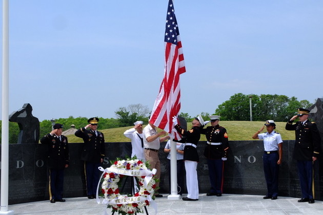 Bob DeFontes, Vice-chairman of the Veterans Memorial Committee raises the American flag at the new Seekonk Veterans Memorial with the help of Staff Sgt. U.S. Marine Andrew Roberson on Saturday, May 28.