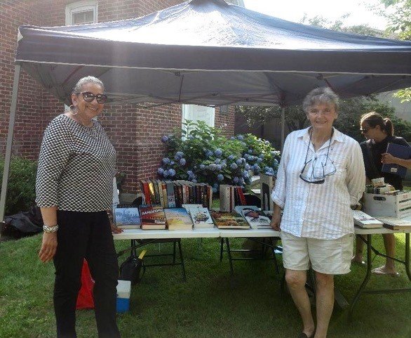 Liz Lombard and Dianne Griffin prepare for the Friends of the Library pop-up book sale at the Weaver Library Farmers Market.