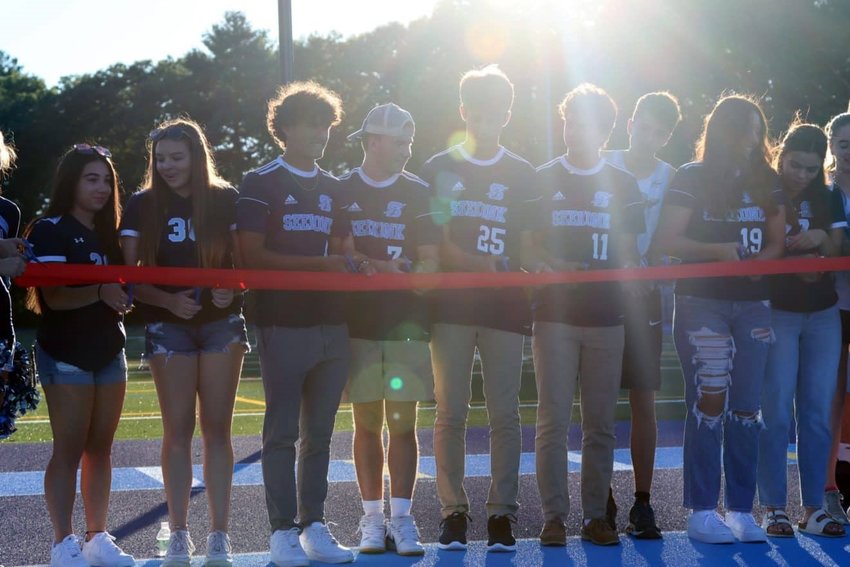 Captains from various SHS athletic teams cut the ribbon for the new Connolly Turf Field and Mooney Track at Seekonk High School last week.