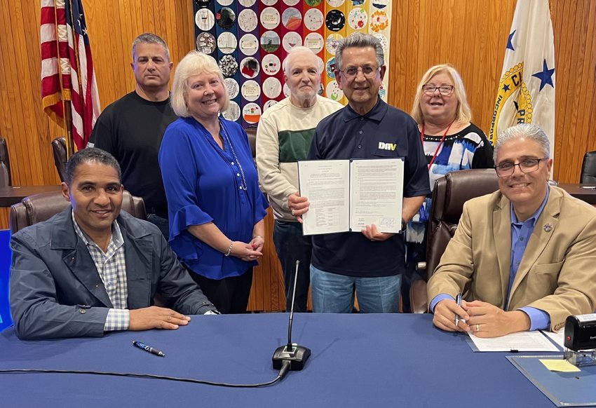 Council President Britto and Mayor Bob DaSilva sign ordinance expanding exemptions for veterans.   Veteran Antonio Ballirano, holds his copy of the ordinance, after having worked with the city on the exemption.