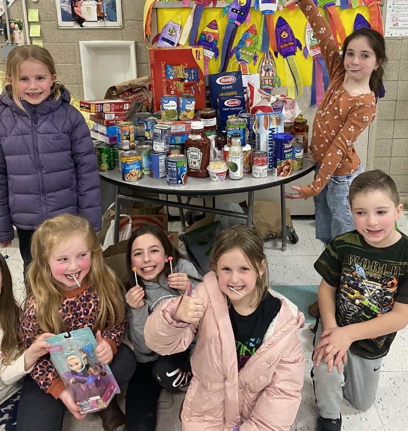 Aitken School students pose with some of the food collected on Bingo Night