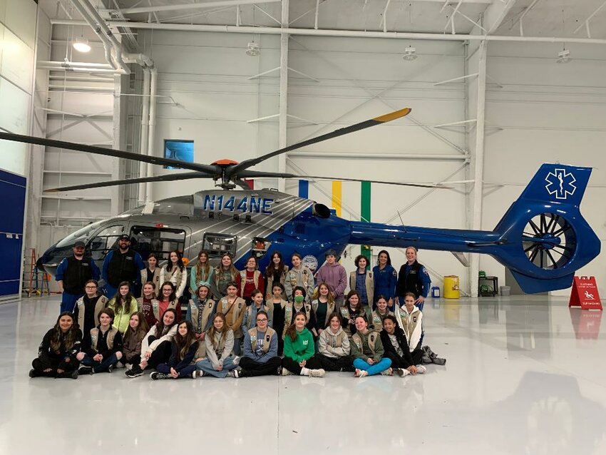Girl Scouts from Southeastern New England - including East Providence Troops 417 and 519 - are shown standing in front of the Boston MedFlight helicopter.  Also included in the picture are some its medical crew members.