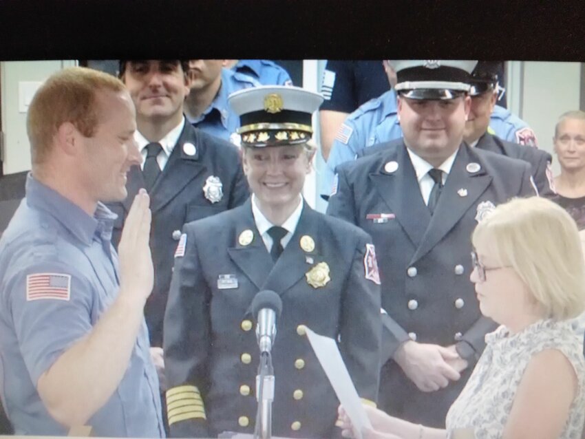 Firefighter Andrew Jacobs being sworn in by Town Clerk Florice Craig.