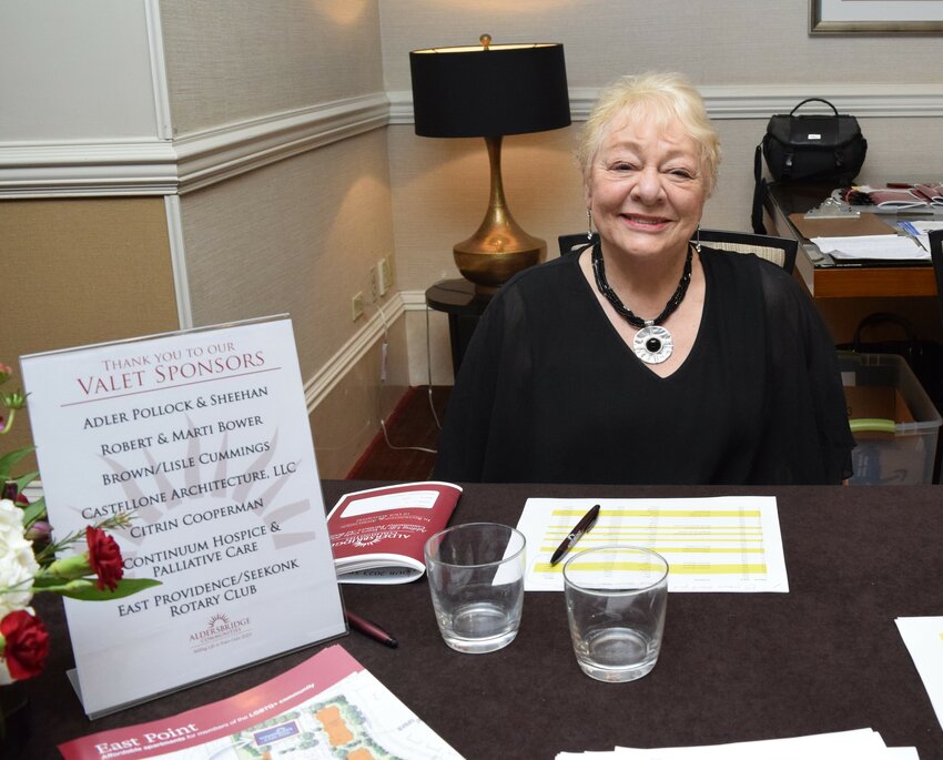 East Providence resident and former City Councilor/City Clerk Valerie Perry, a trustee of Aldersbridge Communities, works the registration table welcoming guests.