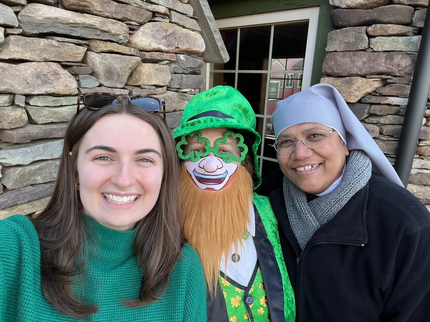 . Staff member Michaela Gallagher and Sister Laurelliya pose with Lucky the Leprechaun.