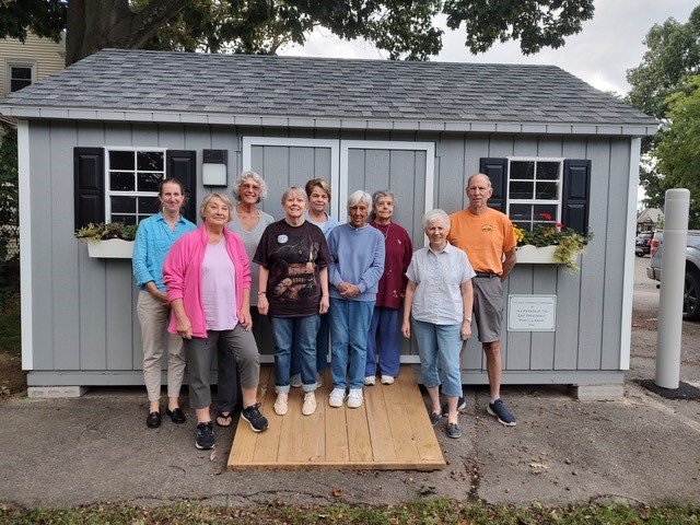 Friends in front of shed they purchased for Weaver Library. Left to right: Meredith Bonds-Harmon, Director of EP Public Library, Rose Sirenski, Lu Rodrigues, Jean Zunda, Ginnie Hogan, Shirley Freeman, Sharon DuBois, Louise Paiva and Don Paiva.