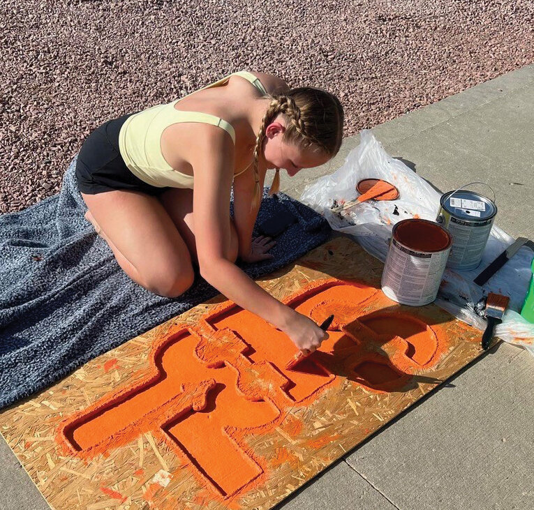 Ella Jensen, a new SBL Dazzler, works on painting a driveway sign,