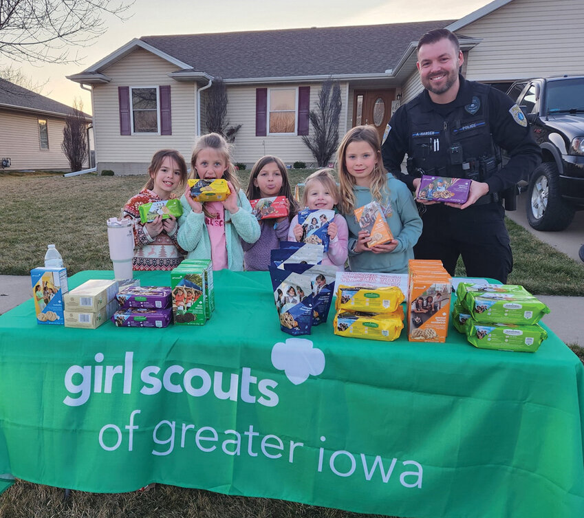Officer Andrew Hansen supports Sergeant Bluff Girl Scouts as they sell delicious treats during the Girl Scouts of America annual cookie drive.