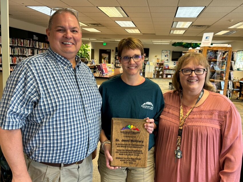 Dr. Jenni McCrory (center) received a plaque from Sergeant Bluff Public Library Board President Michael Aguirre (left) and Library Director Mary Torgerson.