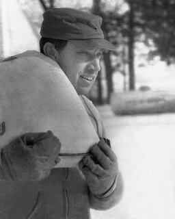 Senator Grassley carries feed sack on family farm.