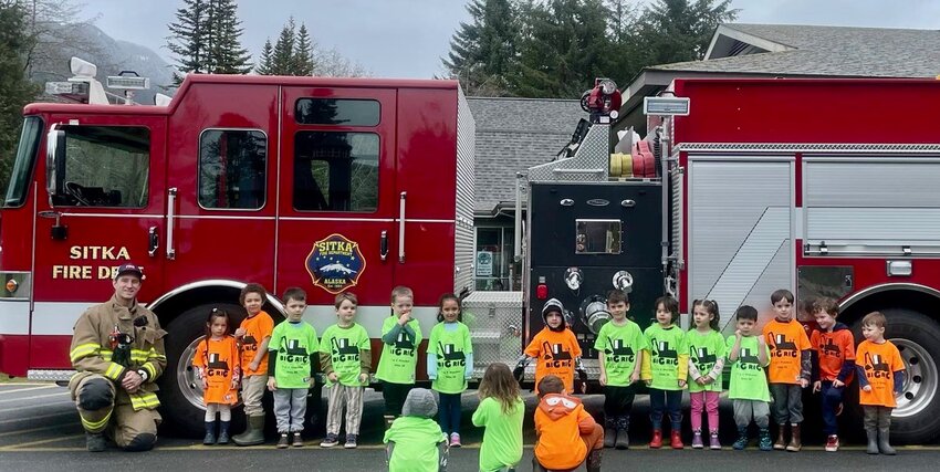 BIG RIG FUN – Students from 3 to 5 Preschool stand in front of the fire truck that will be at the Big Rig fundraising event 10 a.m.-2 p.m. Saturday, April 26, at Mt. Edgecumbe High School parking lot. Attendees may place their name into a fire truck piñata for a raffle. The winner (and four others) will get to ride on the fire truck at a later time. A wide variety of vehicles will be available to view, and to climb on with support of the many businesses and individuals. Admission is $5 per person or $20 for a family of four or more. The T-shirts the preschoolers are wearing will be for sale at the event. Food will be available. (Photo provided to the Sentinel)