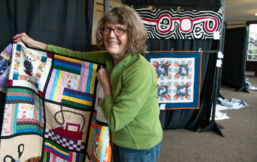 Janine Holzman holds up one of the quilts that will be on display at Fraser Hall on the SJ campus as part of the Ocean Wave Quilt Guild’s annual show. (Sentinel Photo by James Poulson)