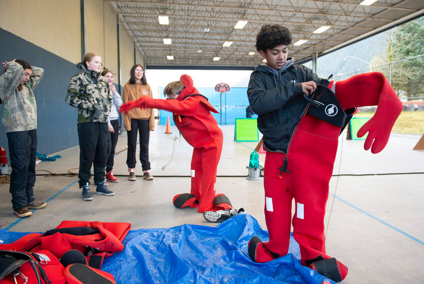 REVIVED SAFETY FAIR – Blatchley Middle School seventh-grader Zian Manuel-Cabudol dons a survival suit in a relay race orchestrated by the U.S. Coast Guard Aids to Navigation Team outside the school on May 2. Alaska Marine Safety Education Association’s AmeriCorp Volunteer Romi Manela was one of the main organizers of the revived Safety Fair, which went dormant in 2019 during the COVID pandemic.
