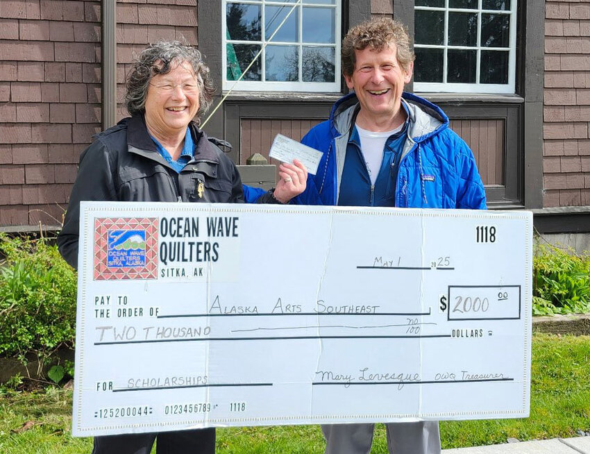 CAMPER MONEY - Sitka Fine Arts Camp director Roger Schmidt receives a check from Ocean Wave Quilters guild president Megan Pasternak for $2,000 for scholarships for campers this summer. Funds were raised at Ocean Wave Quilters guild’s annual auction. (Photo provided to the Sentinel)