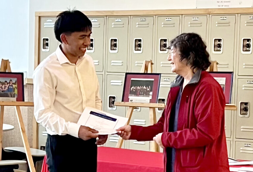 SCHOLARSHIP PRESENTATION – Megan Pasternak presents a $1000 scholarship to Rex Adres, Sitka High graduate, from Ocean Wave Quilters guild. The group holds an annual auction of mini-quilts and related items to raise funds for scholarships. Thanks to a donation of items from the estate of Bobbie Leichty, this year the guild was able to award two scholarships to Mt. Edgecumbe High seniors, one to a Pacific High senior and one to Adres in addition to one to Sitka Fine Arts Camp. (Photo provided to the Sentinel)