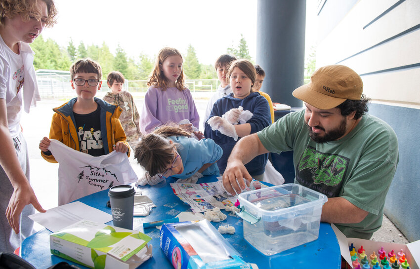 Adam Lechowicz, right, leads a tie-dye workshop outside Blatchley Middle School this afternoon. The workshop is one of several offered by Sitka Parks and Rec this summer.