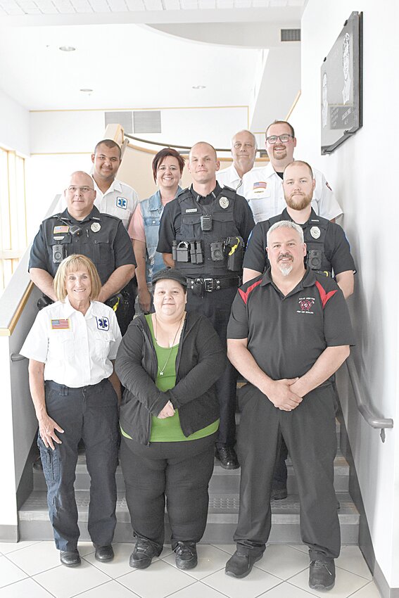 Nicki Hammond (front, center) and her rescuers — EMT Joyce Hunstiger (front, from left) and EMT Jeff Bromenshenkel; (second row, from left) Officer Dean Jungles, Officer Matt Moorman and Officer Landon Gudim; (third row, from left) EMT Jordan Hartmann, firefighter Andrea Kerfeld and paramedic Nick Welle; and (back) EMT Mark Roberg — gather in city hall June 4 in Sauk Centre. The city of Sauk Centre’s emergency personnel assisted in saving Hammond’s life in a choking incident March 9