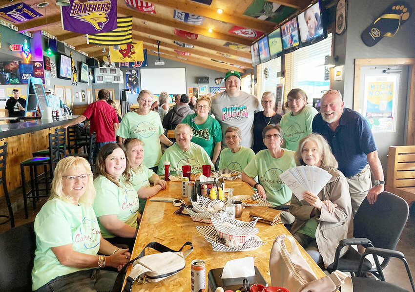 Drew and Lance Bellinghausen are seen with members of Caring Paws Rescue at Puff’s summer kickoff.