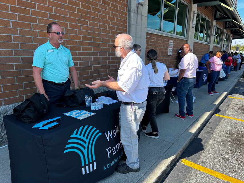 Howard Nettles, from Genesis Healthcare assist attendees at event