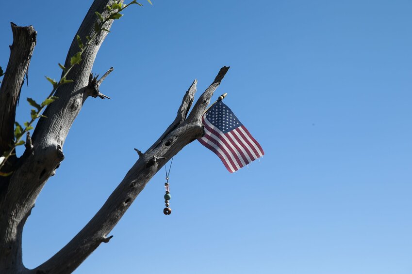 An American flag hangs in a burned tree over the plaque of Granite Mountain Hotshot Dustin DeFord at Granite Mountain Hotshots Memorial State Park. DeFord was only 24 when he died in the Yarnell Hill Fire. (Photo by Joey Plishka/Cronkite News)