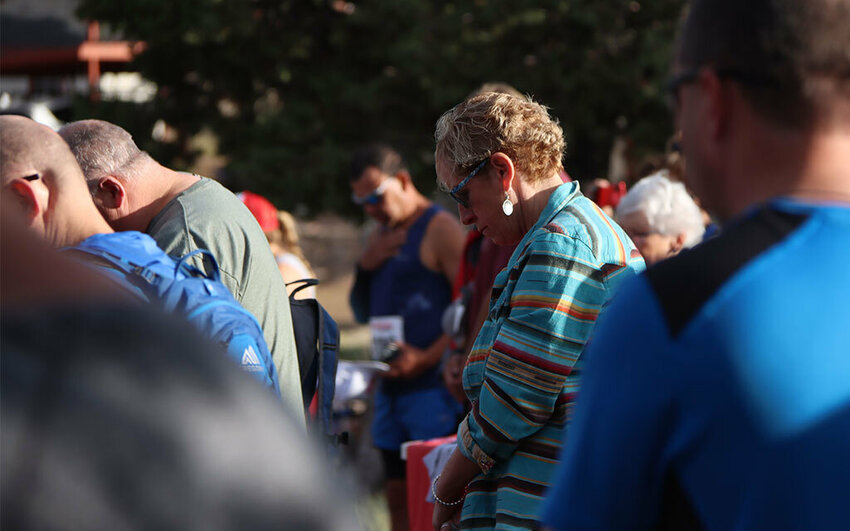 Spectators participate in a moment of silence honoring the 19 fallen members of the Granite Mountain Hotshots before the first race of the recent Yarnell Memorial Run. (Photo by Sean Lynch / Cronkite News)