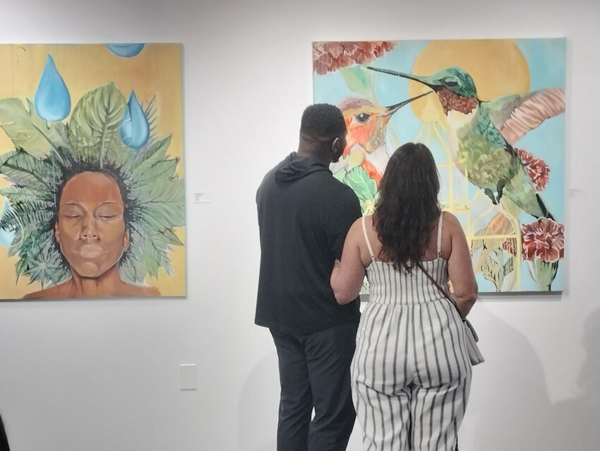 A couple looks at artwork featured at the “IMPRINT: African Americans in the Arts,” exhibit running through March 1, at Arts HQ Gallery in Surprise.