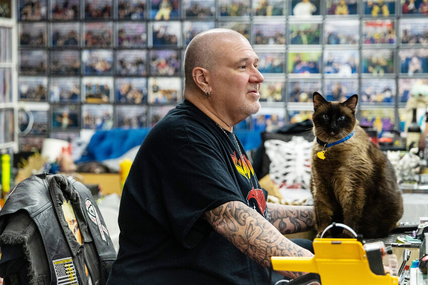 Scott Robenalt, owner of Asylum Records, and the store cat, Hopper, sit behind the register at Asylum Records.  Robenalt said the experience of going into a store and thumbing through records is an experience like no other.