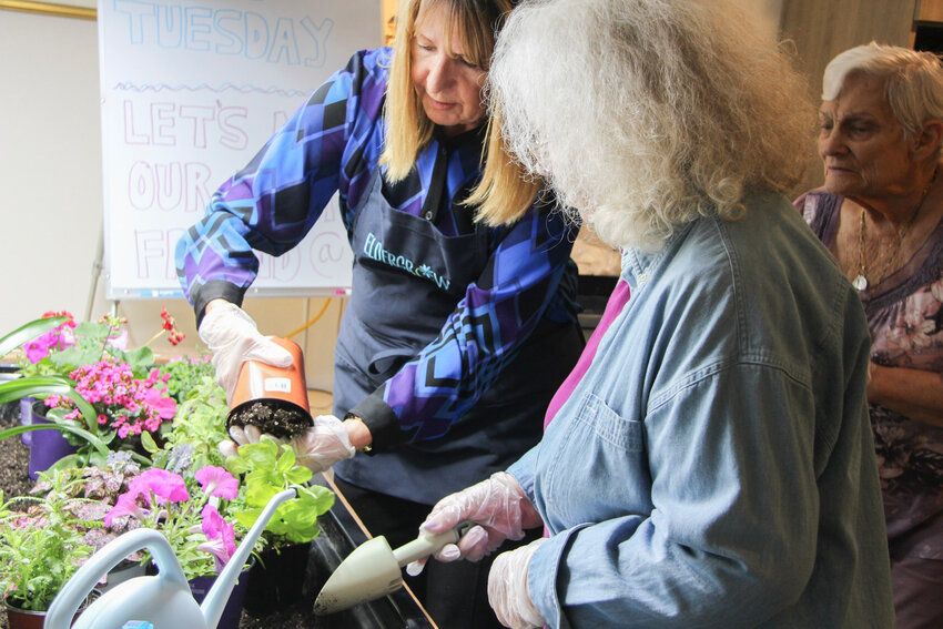 From left, Debra Rowe prepares a basil plant for FVV resident Willow Teagarden to plant. (Independent Newsmedia/Cyrus Guccione)
