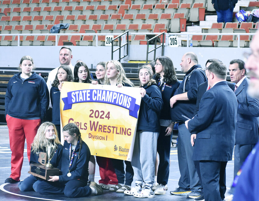 The Liberty girls wrestling team poses for a photo with its third consecutive state team championship trophy Saturday during the state championships at Veterans Coliseum. 