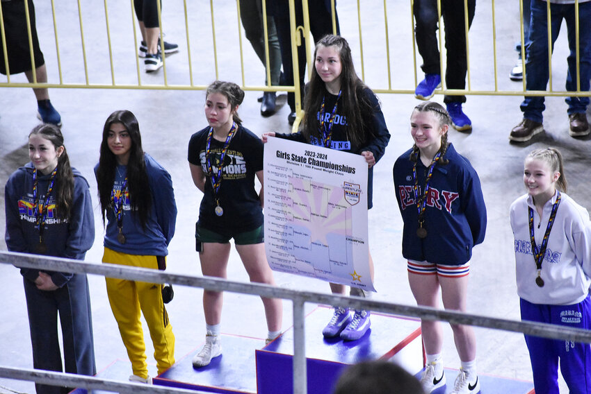 Basha’s Athea Valenzuela, third from the left, and  Perry’s Addison Palmer, wearing Perry High School colors, flank Division I girls Division II 100-pound champion, Kennedy Farrar of Gila Ridge, during a state wrestling top-six ceremony Feb. 17 Veterans Coliseum. Valenzuela is the runner-up while Palmer placed third.