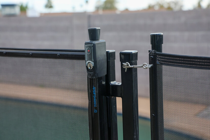 The indicator for the pool safety fence in Sam Aguilar and Brandi Stoll’s shows red, indicating it’s locked on Feb. 21, 2024, in Phoenix. Aguilar and Stoll installed this protective fence around their pool after their daughter, Alizah, then almost 2, nearly drowned.