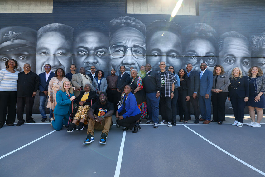 Loved ones of the people featured on the mural at Eastlake Park Community Center in Phoenix pose with local leaders at the unveiling of the NCAA Men’s Final Four Legacy Project event on April 2. (Photo by Kayla Mae Jackson/Cronkite News)