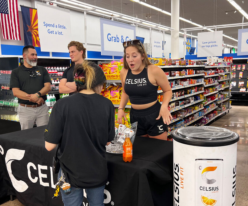 Celsius representatives look over their display at a May 17 ribbon cutting for a remodel of the Walmart Supercenter at Warner and Alma School roads in Chandler.