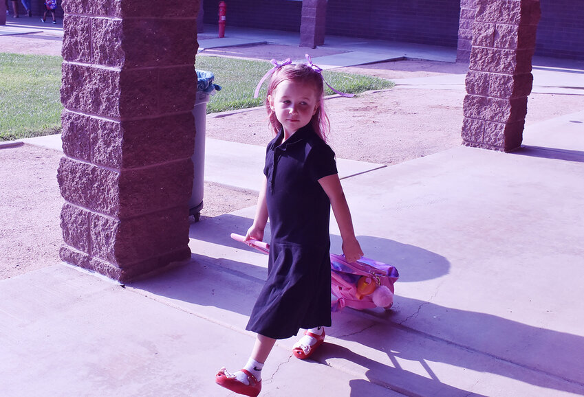 Shumway Leadership Academy student Ayla Schaeffer pulls her kitty backpack toward her classroom on July 17, the first day of the Chandler Unified School District school year. 