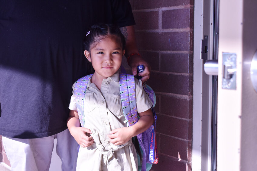 Kindergartner Kinzley Bush is ready for class with her backpack on at  Shumway Leadership Academy teacher, Karina Bolaños, on July 17, the first day of the Chandler Unified School District school year.