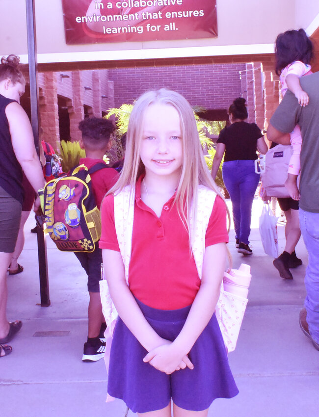 Third-grader Jayla Vera-Martinez poses for a photo in front of Shumway Leadership Academy on July 17, the first day of the Chandler Unified School District year. 