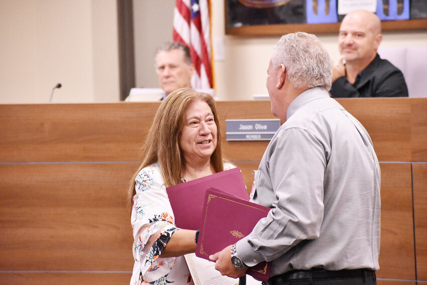 Rose Escalante, a paraeducator at Perry High School, smiles and shakes hands with Chandler Unified School District Superintendent Frank Narducci during a Hispanic Heritage Month recognition event. 