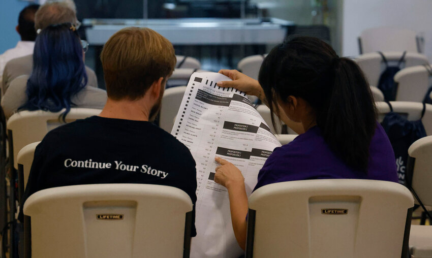 A large print Braille ballot is passed around for the Spark the Spectrum audience to get an idea of what accessible resources are available for voters with disabilities. Photo taken in Phoenix on Sept. 16, 2024. (Photo by Gabriel Garza/Cronkite News)