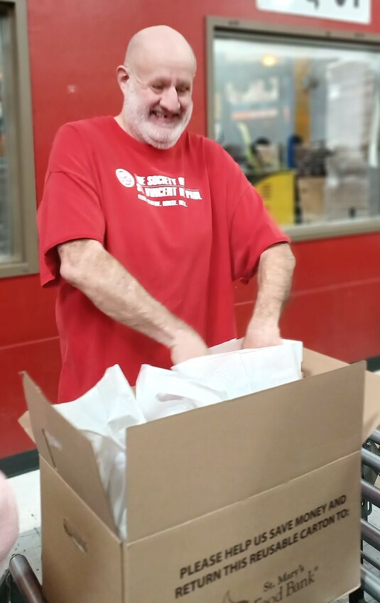A resident packs a food box during Everlasting’s weekly volunteer trip to St. Mary’s Food Bank in Phoenix.